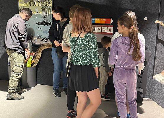 Grupa ludzi na sali wystawowej.